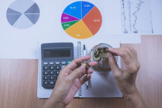 Businessman process with stack coins. Businessman working the project on table.