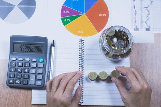 Businessman process with stack coins. Businessman working the project on table.