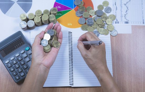 Businessman process with stack coins. Businessman working the project on table.