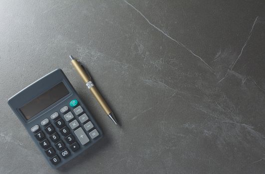 Top view office table calculator with pen on the table for business and copy space.