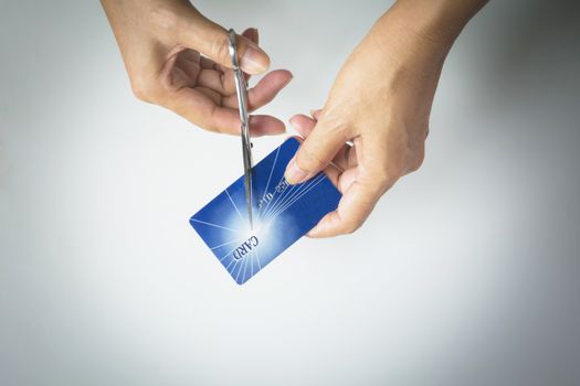 Cutting credit cards with scissors. Female hands cutting credit card with scissors.