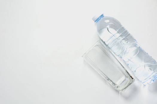 Water glass with bottle on white background with copy space.