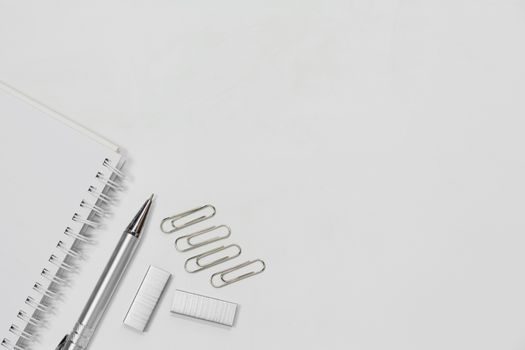 Top view of note book, pen and paper clip isolated on white background with copy space. 