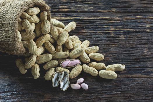 Peanuts in sack on wooden table background. peanut in shell.