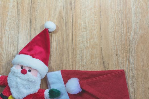 Santa Claus doll with Santa Claus red hat in Christmas day on wooden background with copy space