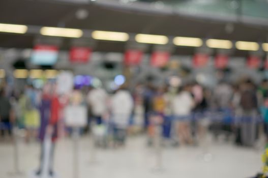 Abstract blurred passenger with suitcase waiting for check in at airport terminal. Business tourism and rush concept photography.