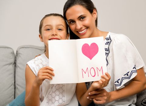 Mother receiving a greeting card on mother's day from her daughter