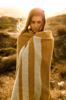 Beautiful young woman walking over a wood path wrapped with a wool towel