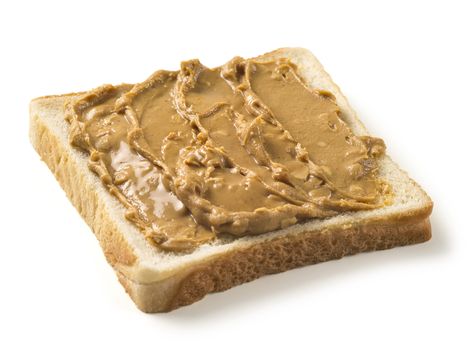 Photo of a slice of white bread covered in peanut butter. Isolated on white with clipping path included.
