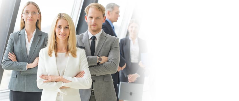 Successful business team with arms crossed at the office, white copy space