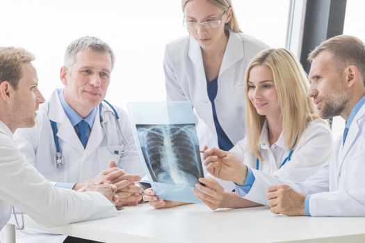 Healthcare, medical and radiology concept - group of doctors looking at x-ray