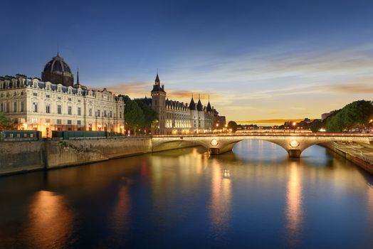 Consiergerie, Pont Neuf and Seine river with tour boat at sunny summer sunset, Paris, France