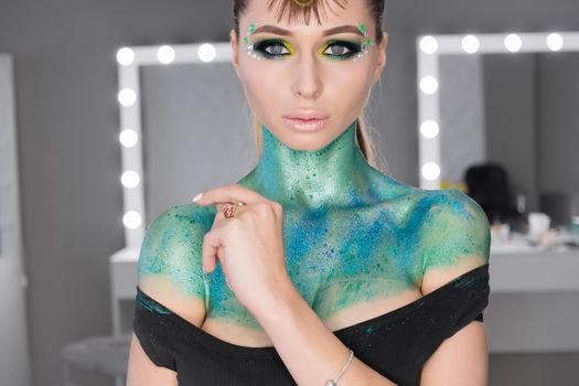 Fashion Art Portrait .Girl with green art makeup.