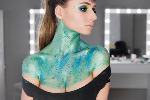 Fashion Art Portrait .Girl with green art makeup.