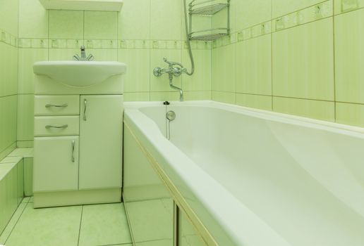 Small green tile bathroom with bath tube and sink