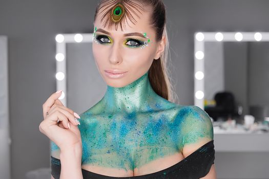 Fashion Art Portrait .Girl with green art makeup.