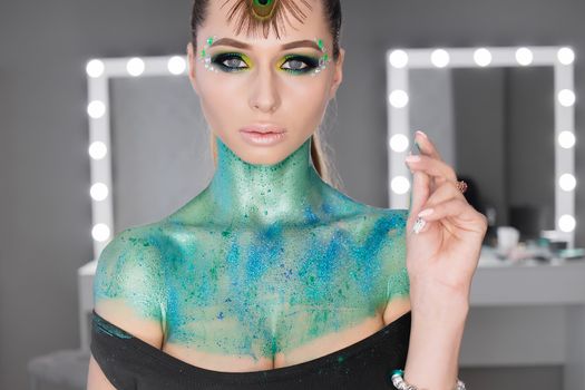 Fashion Art Portrait .Girl with green art makeup.