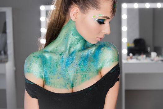 Fashion Art Portrait .Girl with green art makeup.