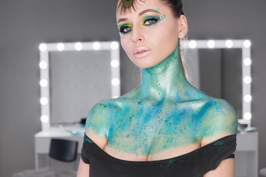 Fashion Art Portrait .Girl with green art makeup.