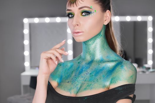 Fashion Art Portrait .Girl with green art makeup.