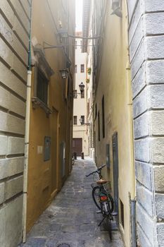 view of a bicycle leaned on a wall of a narrow alley in Florence, Italy