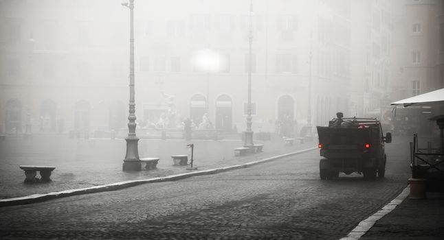 Unusual view of Piazza navona wrapped in fog with a garbage truck moving