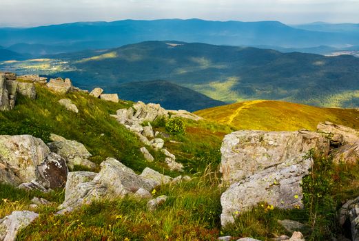 huge rocky formations on the grassy hills. beautiful mountain landscape in late summer on a cloudy day. location Runa mountain, Ukraine