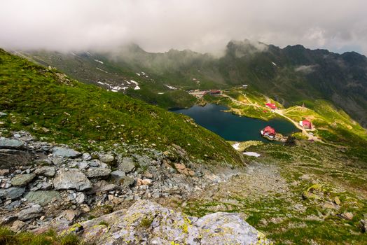 area of lake Balea in clouds. Gorgeous summer landscape of Fagarasan mountains, Romania. popular tourist location observed from the top of the ridge