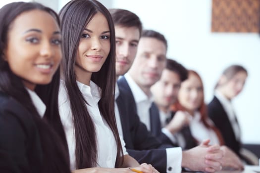 Business people sitting in a row and working, focus on pretty woman
