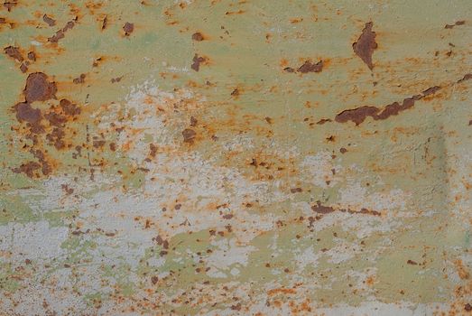 fragment of a rusty iron surface covered with old paint, which has long been under the influence of different climatic conditions