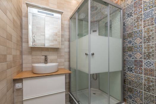 Small beige tile bathroom with Shower cabin and sink