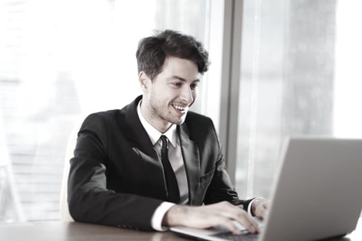 Busy businessman in office working on his laptop.