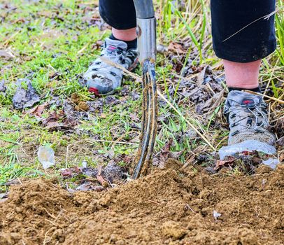 Woman digging soil with garden fork. Gardening and hobby concept. Gardening in the spring. 