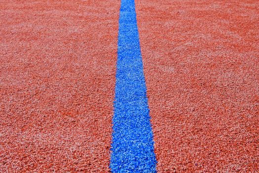 Blue line on red playing field. Copy space. Sport texture and background. 