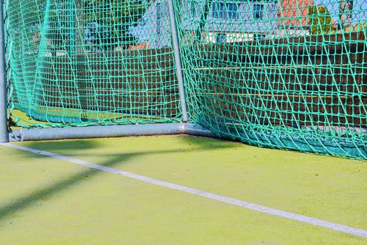 Goal with net and green playing field. Closeup. Sport texture and background. 