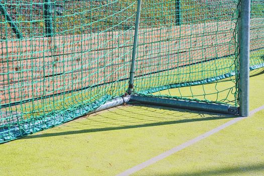 Goal with net and green playing field. Closeup. Sport texture and background. 