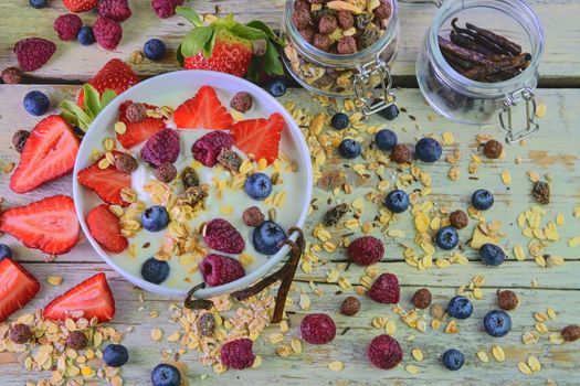 Composition of a typical genuine breakfast made with yoghurt, blueberries, raspberries, blueberries, muesli. Concept of: fitness, diet, wellness and breakfasts. Flat design Top view