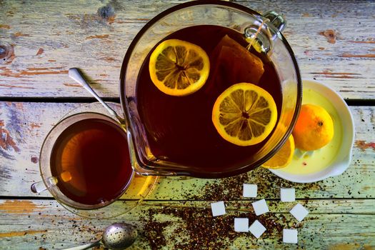 Black tea, a cup of black tea, manual squeezer with lemons. A jug of black tea and cubes of sugar. Top view, flat design.