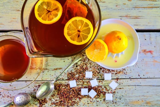 Black tea, a cup of black tea, manual squeezer with lemons. A jug of black tea and cubes of sugar. Top view, flat design.