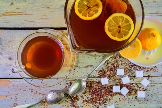 Black tea, a cup of black tea, manual squeezer with lemons. A jug of black tea and cubes of sugar. Top view, flat design.