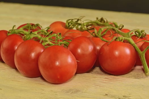 Fresh cherry tomatoes on rustic wooden background. White and black background. 