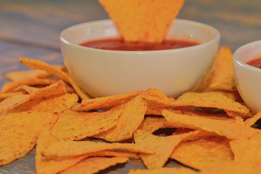 Chili corn-chips with salsa dip on wooden background. 