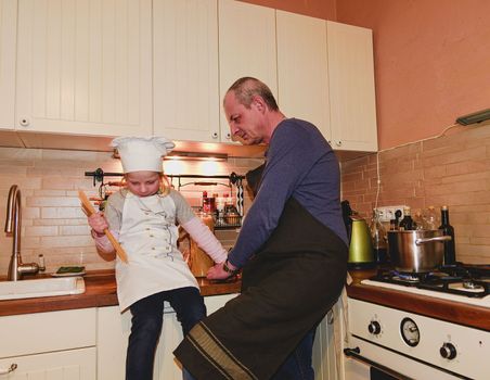 Daughter and father in the kitchen preparing spaghetti to dinner.