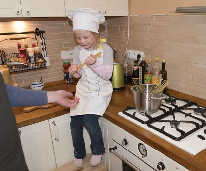 Daughter and father in the kitchen preparing spaghetti to dinner.