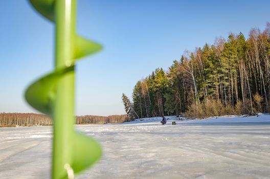 Fisherman alone on ice fishing in the spring