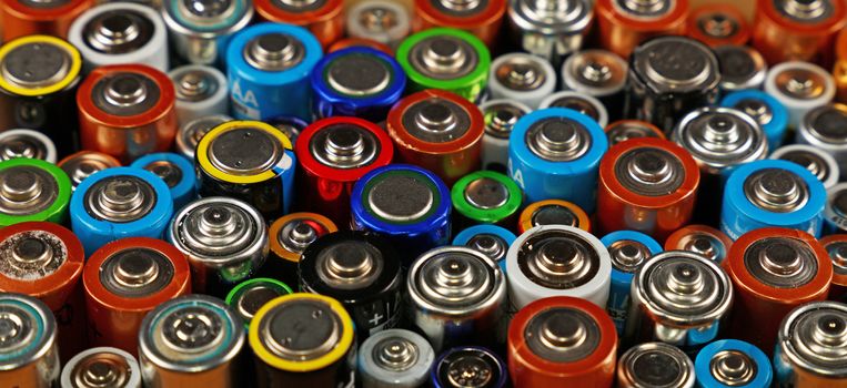 Close up background of assorted colorful electric alkaline batteries