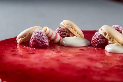 Decoration with raspberries, chocolates and biscuits on a cake