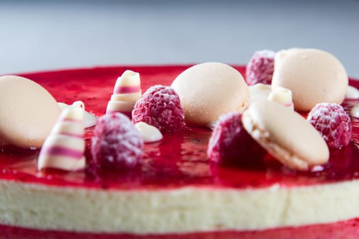 Decoration with raspberries, chocolates and biscuits on a cake