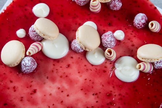 Decoration with raspberries, chocolates and biscuits on a cake