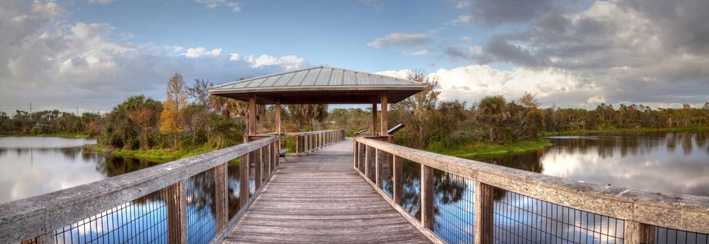 Gazebo on a wooden secluded, tranquil boardwalk along a marsh pond in Freedom Park in Naples, Florida